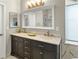 Bathroom boasts double sink vanity, marble counters, and a large mirror with decorative lighting at 5140 Mt Pawnee Ave, Frederick, CO 80504