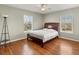 Cozy bedroom featuring hardwood floors, a comfortable bed, and bright windows offering ample natural light at 5140 Mt Pawnee Ave, Frederick, CO 80504