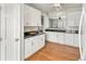 Updated kitchen featuring white cabinets, granite counters, stainless appliances, and hardwood floors at 5140 Mt Pawnee Ave, Frederick, CO 80504