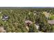 Aerial view of a home surrounded by tall pine trees, with city views and mountain range visible in the distance at 465 Indian Way, Monument, CO 80132