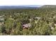 Aerial view of a red brick home surrounded by lush pine trees with mountains visible in the distance at 465 Indian Way, Monument, CO 80132