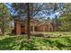 Backyard view of brick home with lush yard and landscaping at 465 Indian Way, Monument, CO 80132