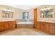 Luxurious bathroom with dual vanities, soaking tub, corner windows, and modern fixtures at 465 Indian Way, Monument, CO 80132