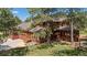 Spacious home featuring a sunroom, two-car garage, and wooden deck, surrounded by mature trees at 465 Indian Way, Monument, CO 80132