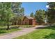 Exterior of home featuring a lush front lawn and mature trees at 465 Indian Way, Monument, CO 80132