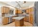 Elegant kitchen featuring wood cabinets, stainless steel appliances, center island, and modern fixtures at 465 Indian Way, Monument, CO 80132