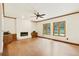 Open living room featuring wood floors, a white brick fireplace, and large windows, perfect for gatherings and relaxation at 465 Indian Way, Monument, CO 80132