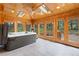 Bright sunroom with hot tub, wood paneled walls, skylights, and tile flooring at 465 Indian Way, Monument, CO 80132