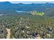 Scenic aerial view capturing the mountain community, golf course, lake, and lush green surroundings at 4228 Scenic Village Dr, Evergreen, CO 80439