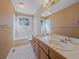 Bathroom featuring double sinks, a soaking tub, and bright lighting at 4228 Scenic Village Dr, Evergreen, CO 80439
