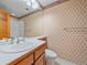 Charming bathroom with patterned wallpaper, a classic vanity, and a shower-tub combination at 4228 Scenic Village Dr, Evergreen, CO 80439
