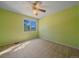 Empty bedroom with green walls, neutral carpet, ceiling fan and sunlit window at 4228 Scenic Village Dr, Evergreen, CO 80439