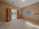 Inviting bedroom with neutral walls, carpet flooring, and double doors leading to a sunroom at 4228 Scenic Village Dr, Evergreen, CO 80439