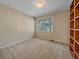 Neutral bedroom featuring neutral carpet, built in shelving, and a bright sunny window at 4228 Scenic Village Dr, Evergreen, CO 80439