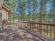 Large wooden deck surrounded by mature trees offers a serene outdoor living space at 4228 Scenic Village Dr, Evergreen, CO 80439