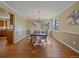 Elegant dining room with hardwood floors, wainscoting, and a chandelier, bathed in natural light from large windows at 4228 Scenic Village Dr, Evergreen, CO 80439