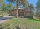 Two-story home featuring a well-manicured lawn and a welcoming covered front entry in a wooded, landscaped setting at 4228 Scenic Village Dr, Evergreen, CO 80439