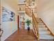 Spacious foyer features wood floors, a staircase with carpet runner, and elegant chandelier lighting at 4228 Scenic Village Dr, Evergreen, CO 80439