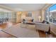Bright living room featuring hardwood floors, crown molding, and large windows offering ample natural light at 4228 Scenic Village Dr, Evergreen, CO 80439