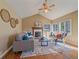 Vaulted living room with fireplace, ceiling fan, and multiple windows overlooking the surrounding landscape at 4228 Scenic Village Dr, Evergreen, CO 80439