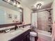 A charming bathroom features warm lighting, vanity with framed mirror and a tub with a shower creating a comforting space at 7872 S Hill Dr, Littleton, CO 80120