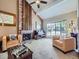 Bright living room featuring a brick fireplace, large windows, and neutral decor at 7872 S Hill Dr, Littleton, CO 80120