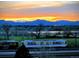 An evening shot captures the neighborhood with mountain views, a pond and a transit train passing by at 7872 S Hill Dr, Littleton, CO 80120