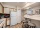 Functional kitchen with ample counter space, white appliances, and a breakfast bar for casual dining at 4301 S Pierce St # 4D, Littleton, CO 80123