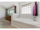 Bright bathroom featuring soaking tub with tiled wall and large window at 29145 E 160Th Ct, Brighton, CO 80603
