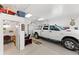 Spacious garage featuring ample storage, a work area, and a parked pickup truck at 29145 E 160Th Ct, Brighton, CO 80603