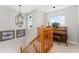 Hallway with wooden banister and piano under a window, illuminated by an ornate light fixture at 29145 E 160Th Ct, Brighton, CO 80603