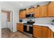 Clean kitchen with stainless steel appliances, wood cabinetry, white countertops, and an adjoining laundry room at 29145 E 160Th Ct, Brighton, CO 80603