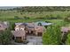 Aerial view of a stone home by a pond and golf course showcasing the lush surroundings and serene environment at 7208 Raphael Ln, Littleton, CO 80125