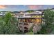 Stone home featuring a large outdoor patio and balcony, with views of the surrounding hillside at 7208 Raphael Ln, Littleton, CO 80125