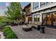 Backyard patio area with fireplace, outdoor seating, manicured landscape and large windows at 7208 Raphael Ln, Littleton, CO 80125