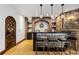 Entertainment bar features stone accents, brick, black countertop, tile floor, and three pendant lights at 7208 Raphael Ln, Littleton, CO 80125