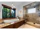 Relax in this luxurious bathroom featuring a soaking tub and glass-enclosed shower at 7208 Raphael Ln, Littleton, CO 80125