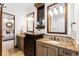 Bright primary bathroom with double vanity, mirrors, and a view into the bedroom at 7208 Raphael Ln, Littleton, CO 80125