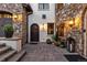 Charming entrance featuring a stone facade, complemented by a dark wood door, arched entry, and decorative lanterns at 7208 Raphael Ln, Littleton, CO 80125
