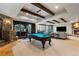 Basement game room with a pool table, stone accents, and access to the backyard at 7208 Raphael Ln, Littleton, CO 80125