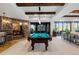 Spacious game room with a pool table, stone accents, and access to the backyard at 7208 Raphael Ln, Littleton, CO 80125