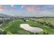 Scenic aerial view of a golf course with ponds and rolling hills, set against a mountain backdrop at 7208 Raphael Ln, Littleton, CO 80125