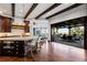 Open concept kitchen featuring hardwood floors, exposed beams, and seamless indoor/outdoor flow to the patio at 7208 Raphael Ln, Littleton, CO 80125
