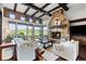 Bright living room featuring stone accents, a fireplace, and large windows with views of the surrounding landscape at 7208 Raphael Ln, Littleton, CO 80125