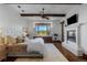 Comfortable main bedroom with a fireplace, TV, window seat with views, and a ceiling fan at 7208 Raphael Ln, Littleton, CO 80125