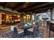 Covered outdoor patio with a built-in grill, dining area, and views of the gourmet kitchen through the door at 7208 Raphael Ln, Littleton, CO 80125