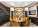 The wine cellar features custom racks with lighting, round table with yellow chairs, and brick floors at 7208 Raphael Ln, Littleton, CO 80125