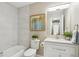 Bright bathroom with marble-look shower tiles and an integrated sink and cabinet at 9777 W 75Th Way, Arvada, CO 80005