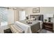 Comfortable bedroom with sliding barn door, neutral tones, and patterned bench at 9777 W 75Th Way, Arvada, CO 80005