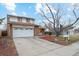 Charming two-story home with a well-manicured front yard and a large driveway leading to an attached garage at 9777 W 75Th Way, Arvada, CO 80005